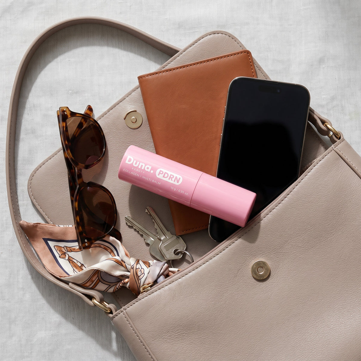 Duna Beauty PDRN Collagen Multi Balm in a handbag, a skincare routine on the go